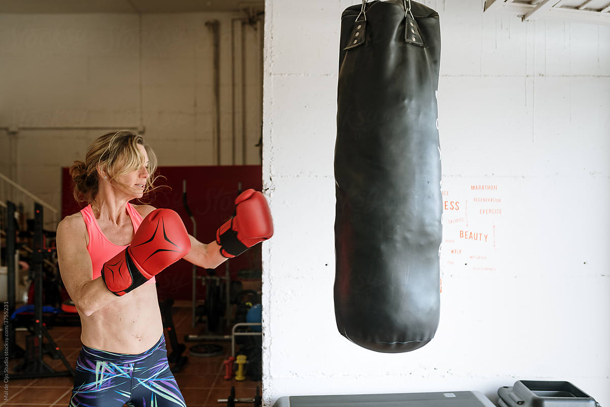 Woman boxing at home with a boxing bag
