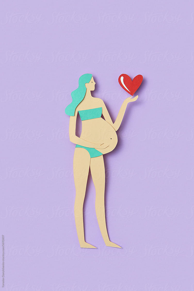 Handcrafted from colorful paper pregnant woman holding heart