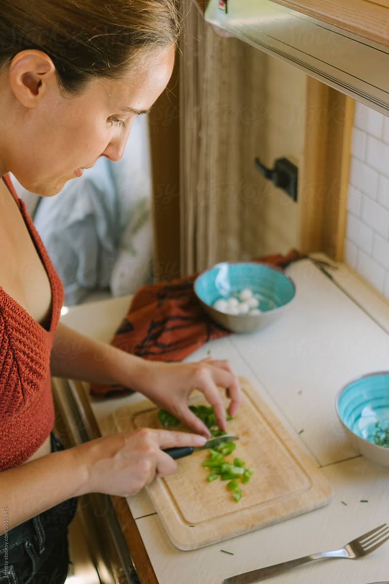 Woman chopping ingredients in a caravan\'s kitchen