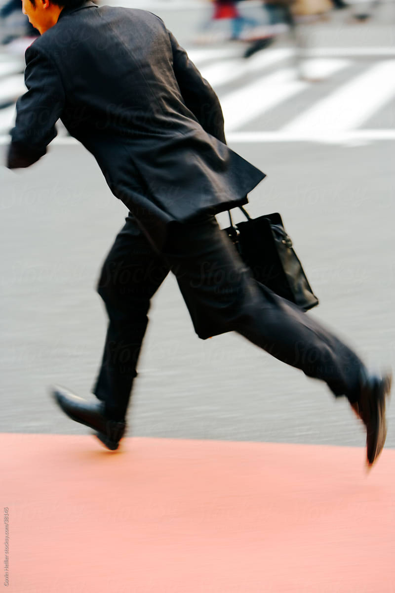 Businessman rushing across a busy intersection