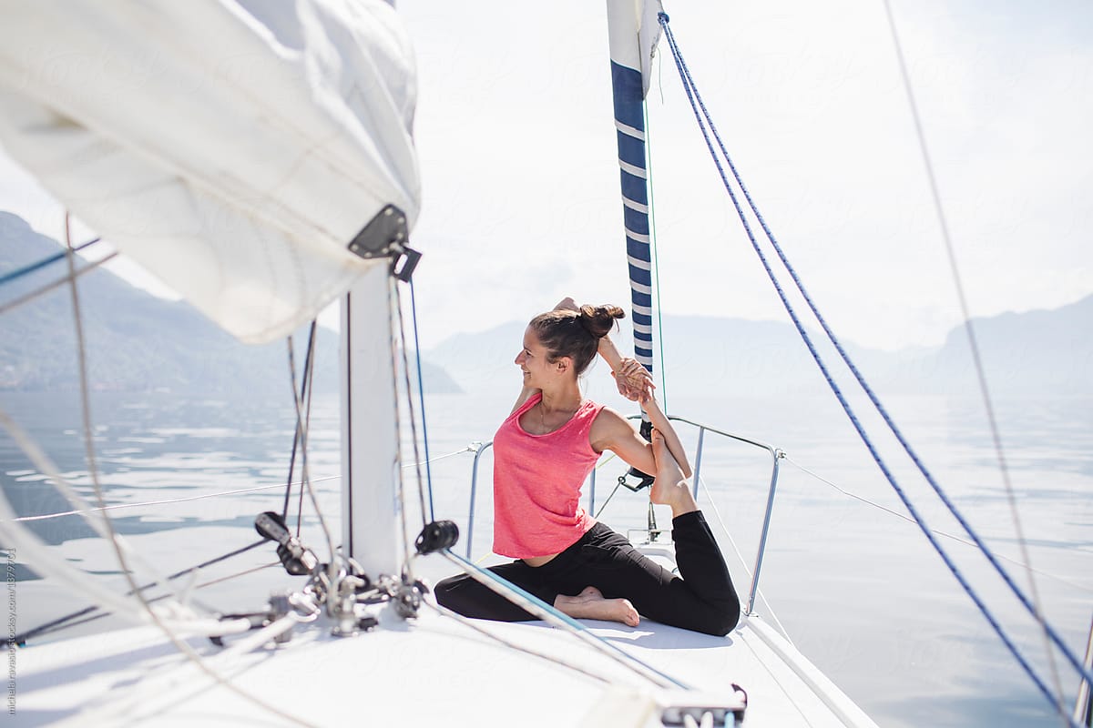 Young woman doing yoga on a sailing boat