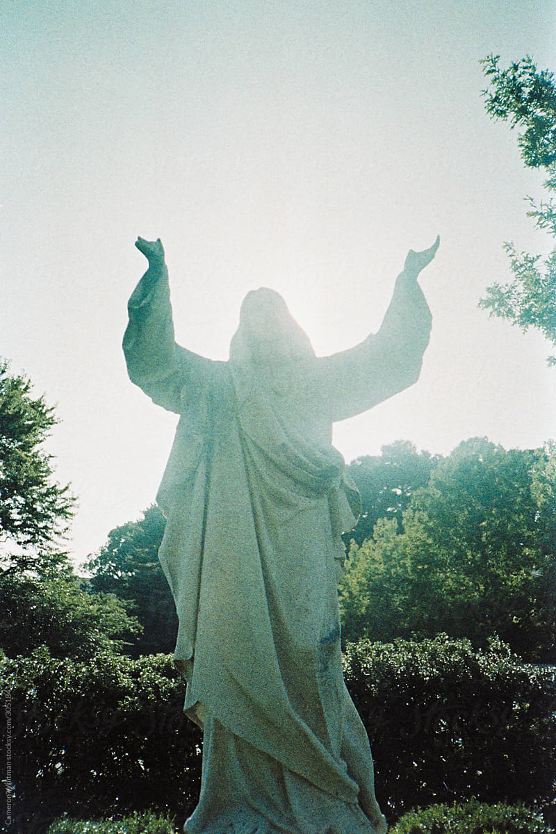 Brightly backlit Jesus Christ statue with broken hands