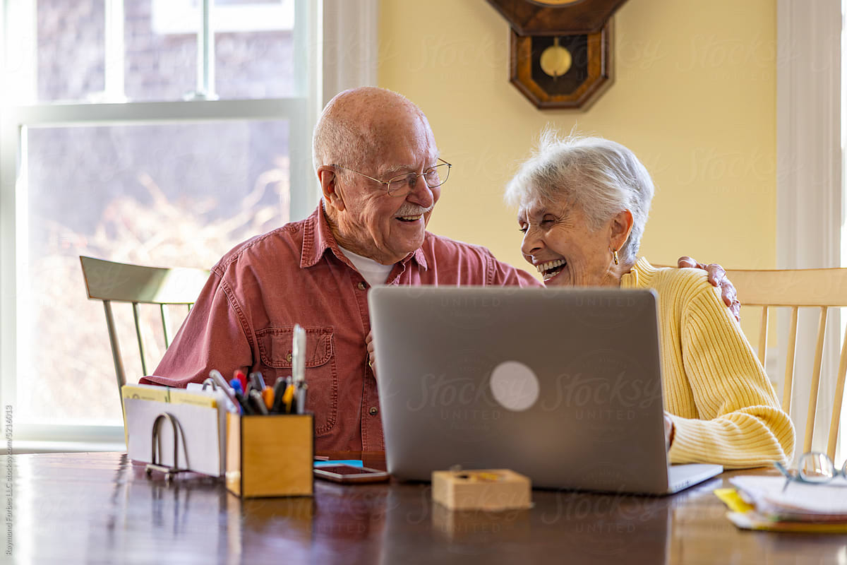Happy Senior Citizen at Home Paying bills family together with laptop