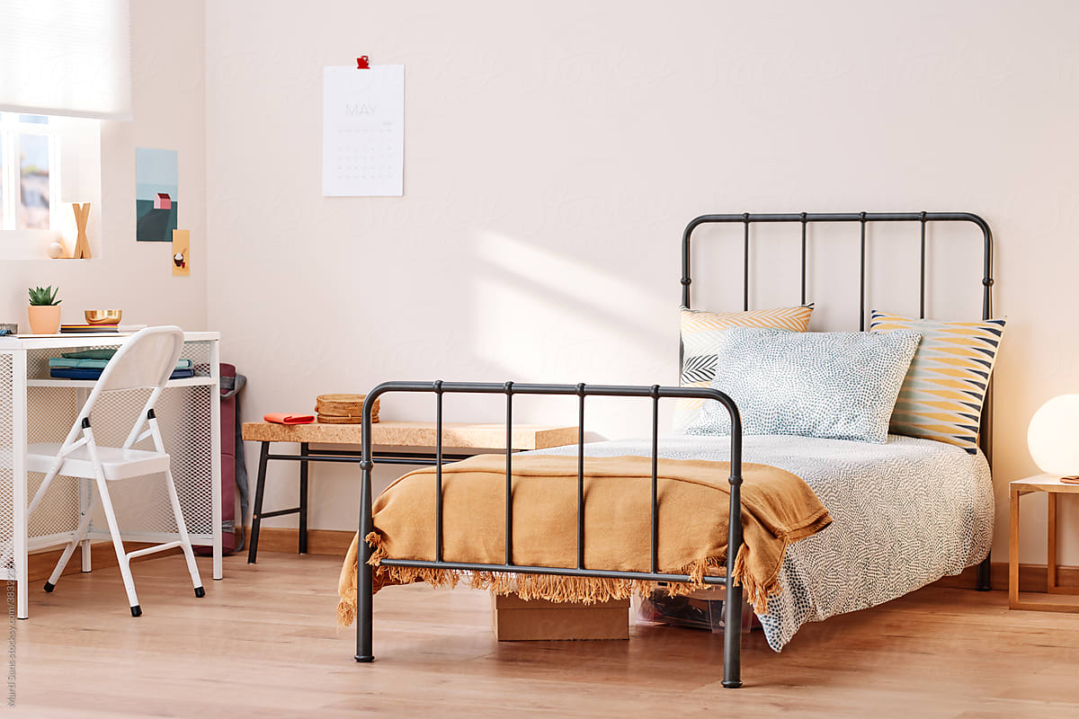 Tidy metal bed with cushions.