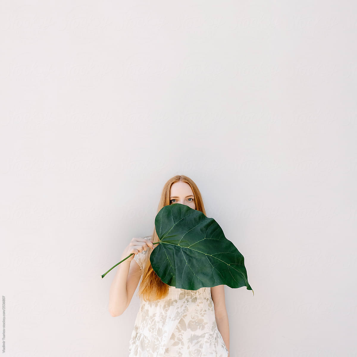 Redhead Woman With Green Leaf Protect Skin On White Background By Stocksy Contributor