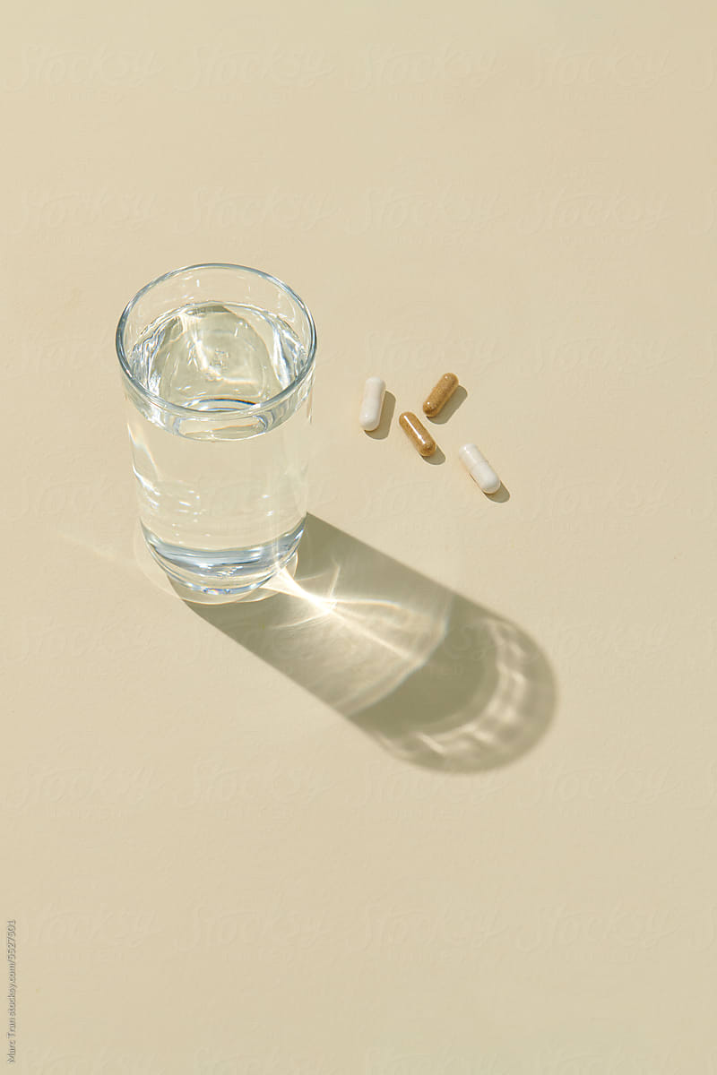 Capsule pills and glass of water