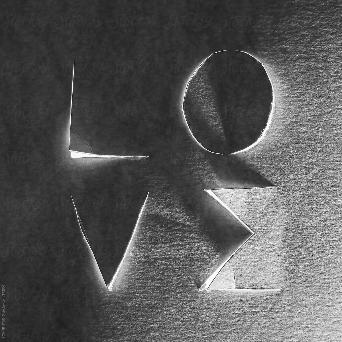 Love word cropped on cardboard. Black and white photo.