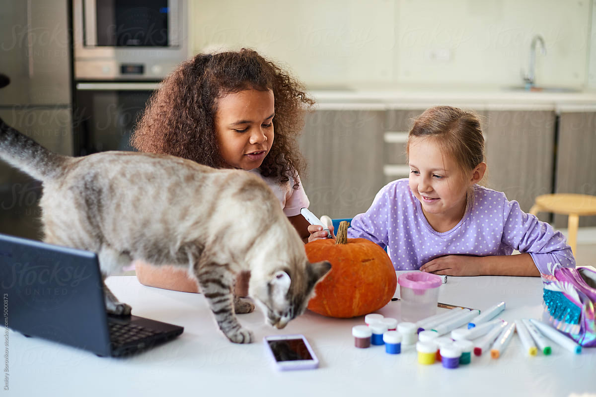Children make pumpkin crafts for halloween at home in the living room