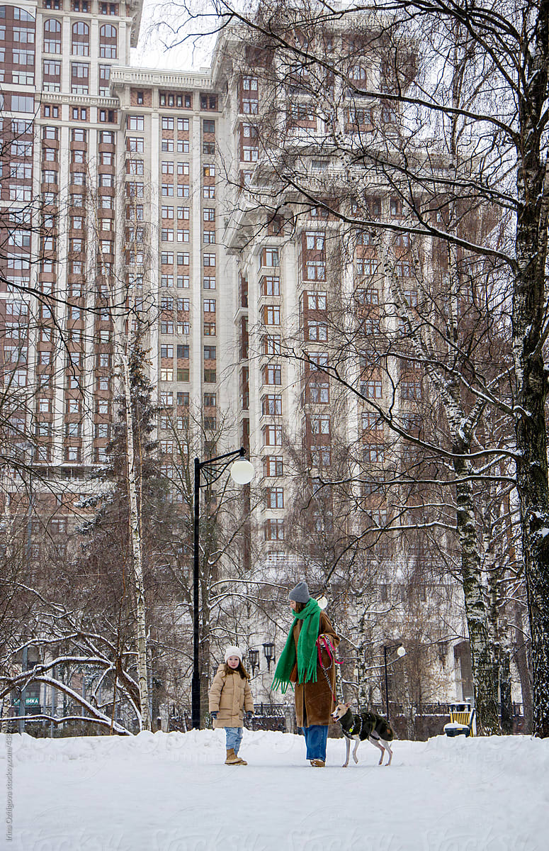 Mom and child with dog in winter city