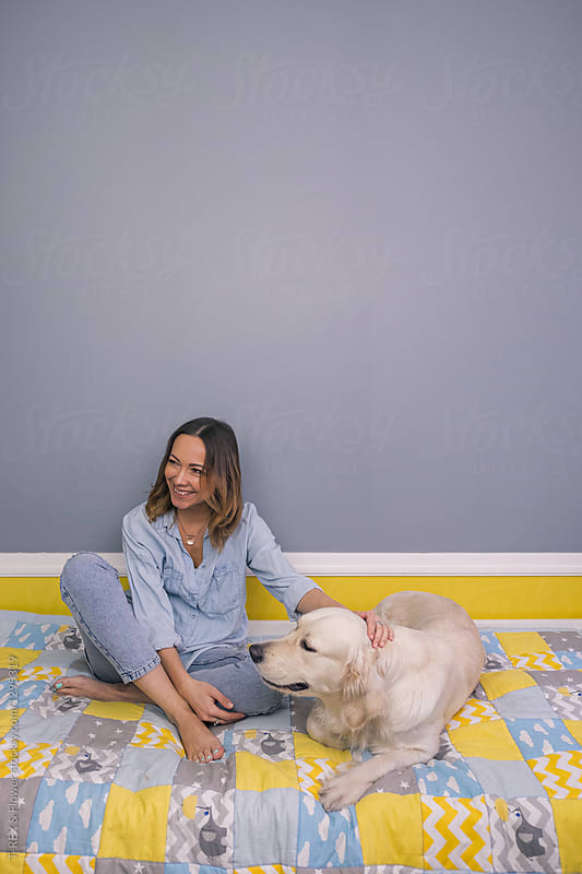 Female with dog on bed