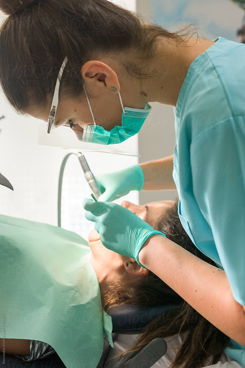 Female Orthodontist Curing Her Patient Using Air Turbine Del Colaborador De Stocksy Ibex