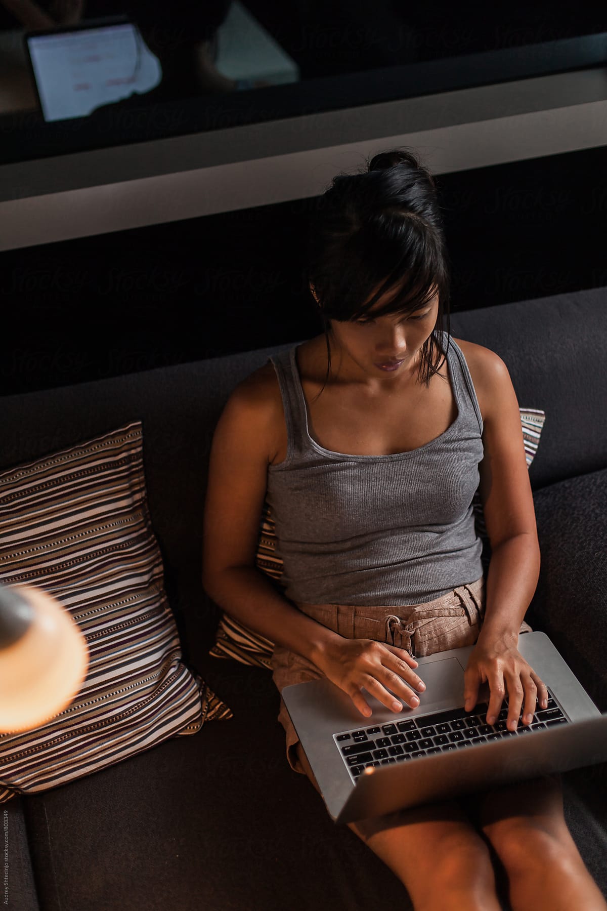 Modern woman in casual outfit  using her laptop during evening.