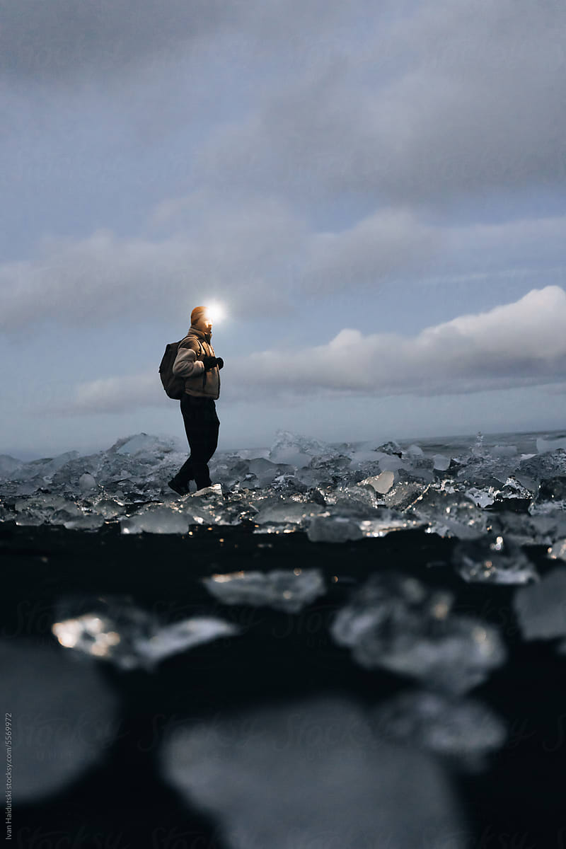 Solo traveler with backpack enjoy ice under cloudy sky in Iceland