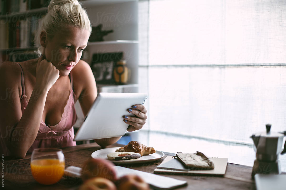 Blonde Caucasian Woman Reading From Her Tablet in the Morning