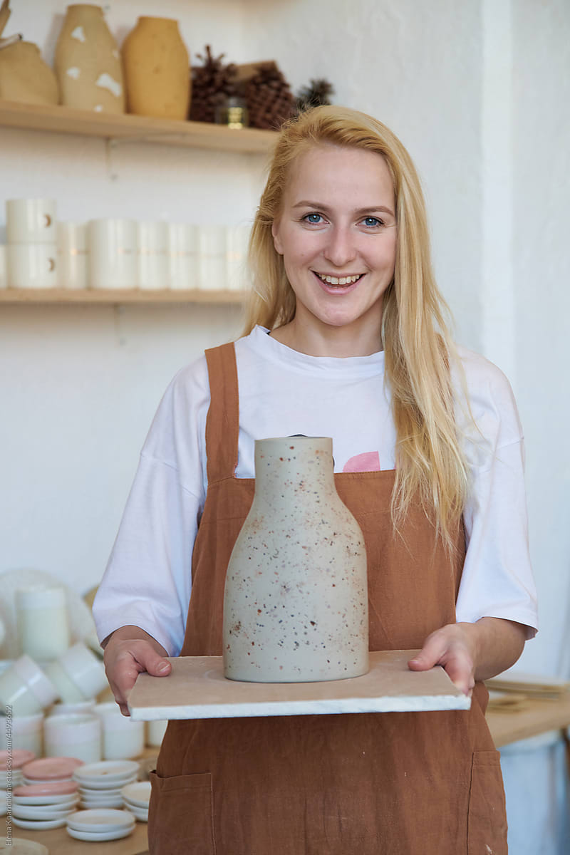 A female ceramist demonstrates a finished vase