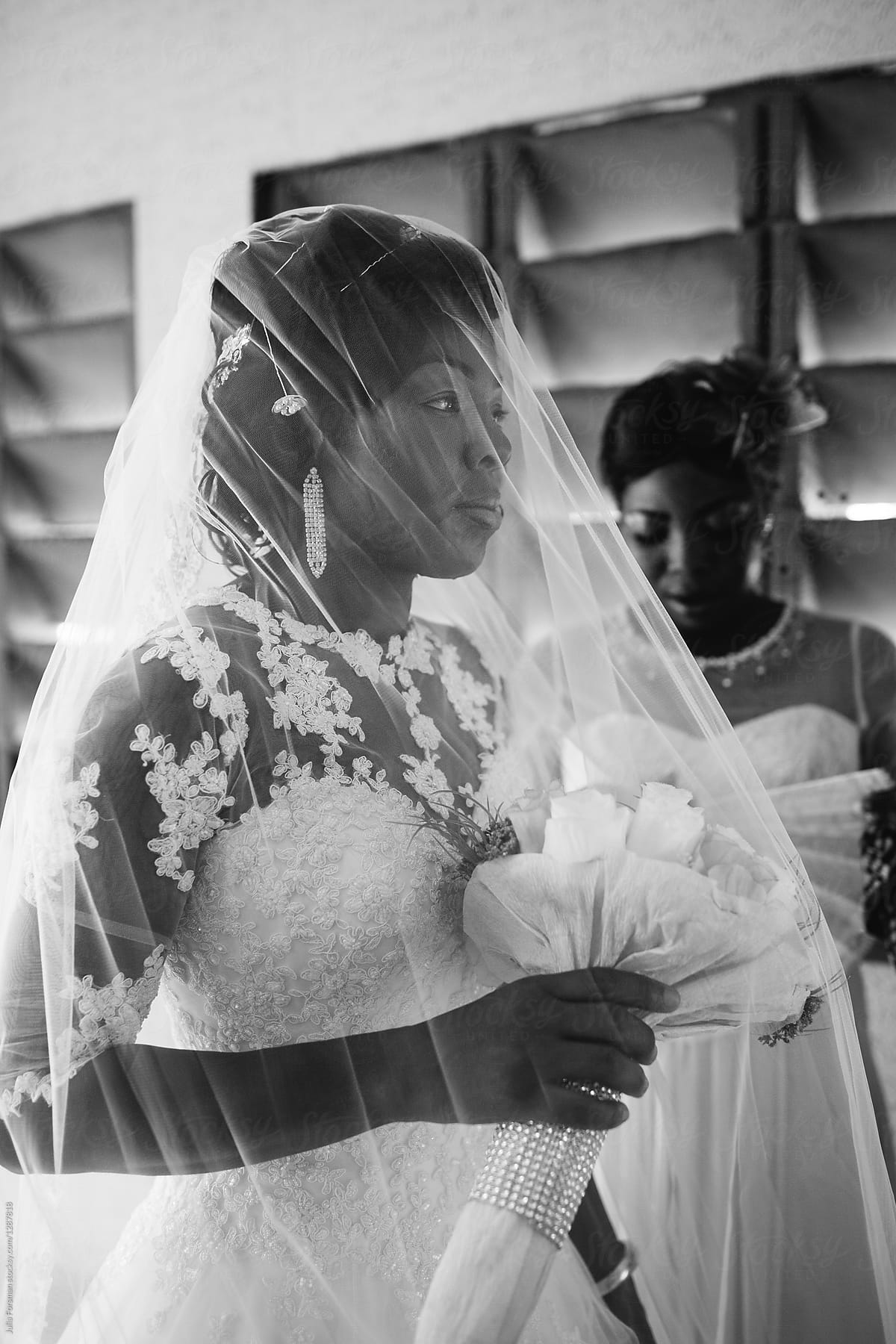 An African bride and her bridesmaid wait to enter the church.