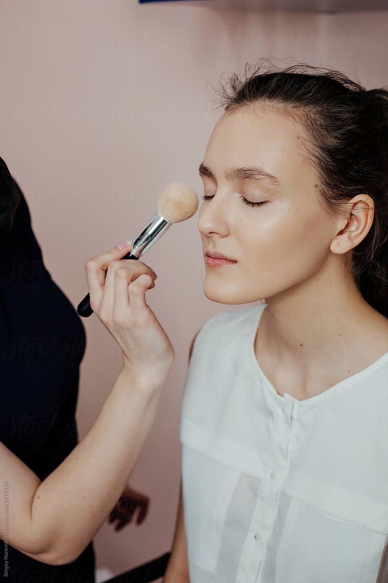 Makeup artist applying makeup on model