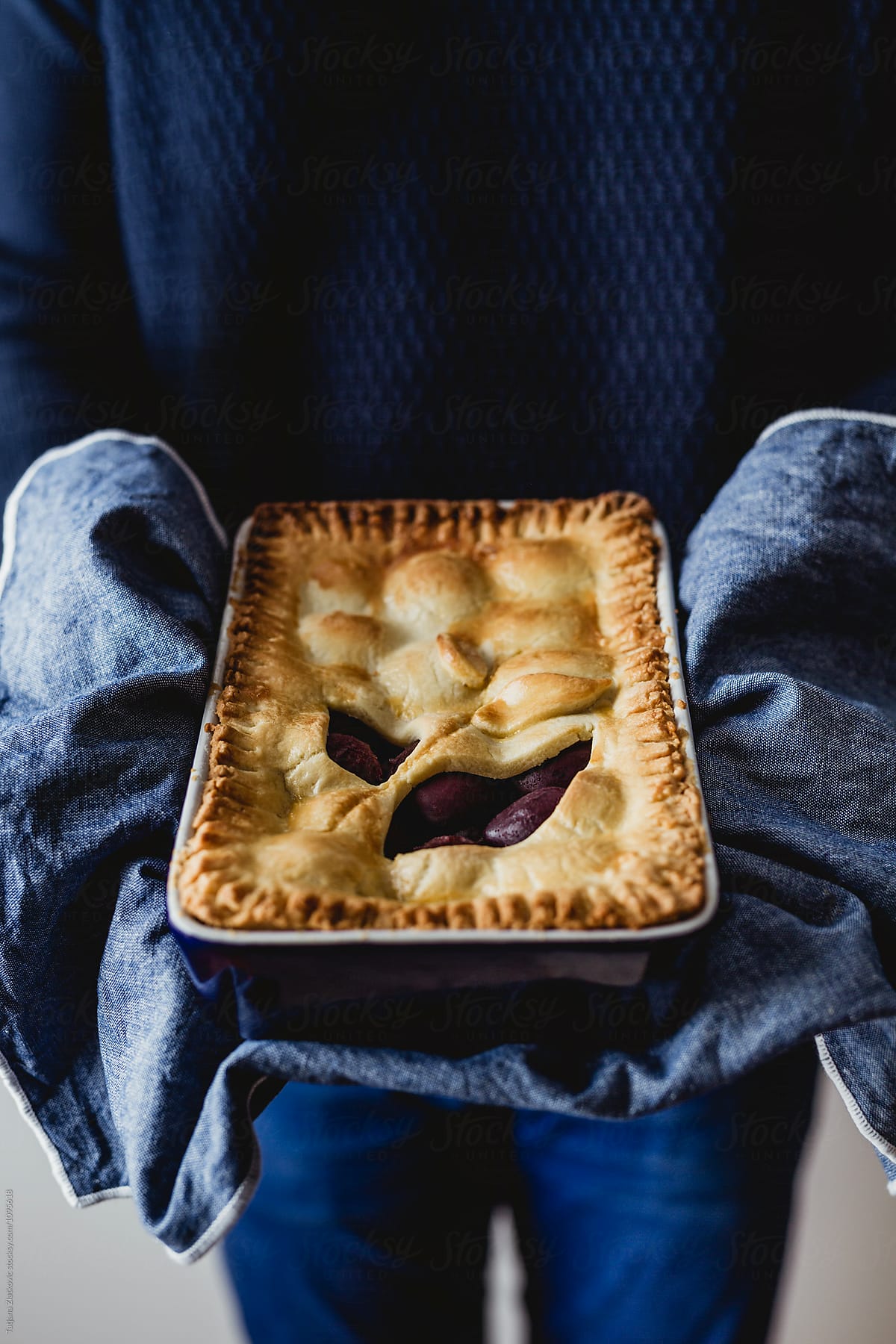 Man is holding plum pie