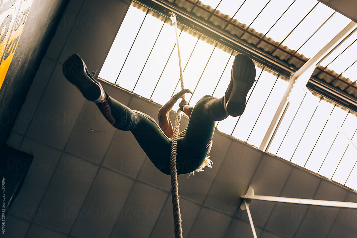 Anonymous athlete climbing rope