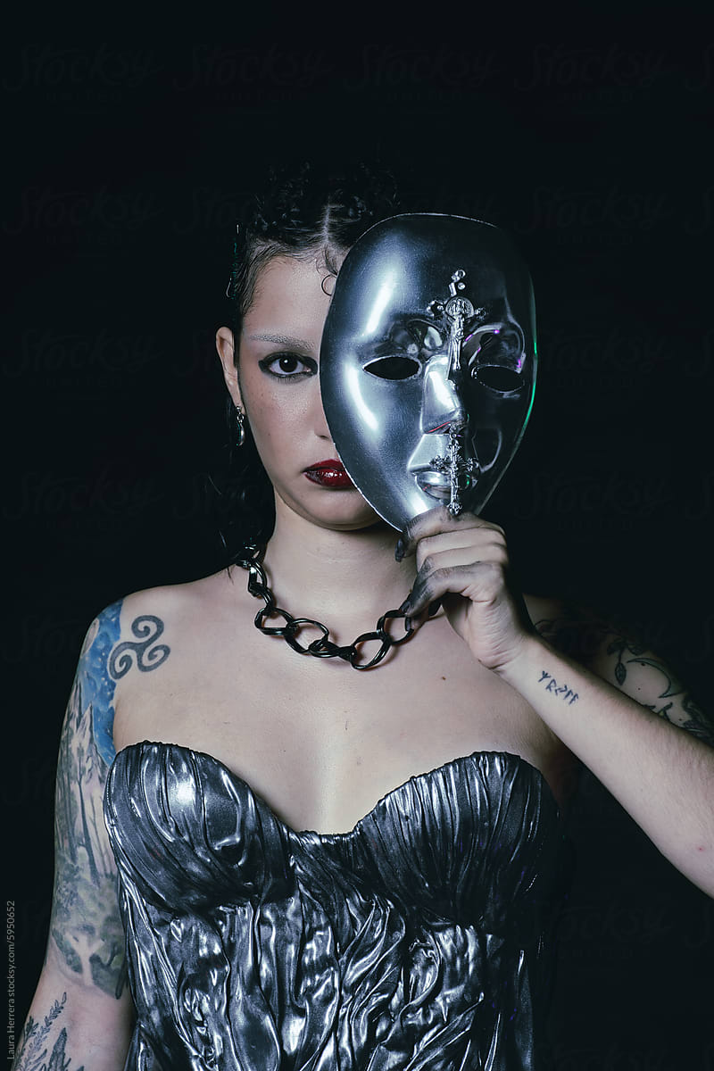 Editorial fashion portrait of a woman with a silver mask and dress