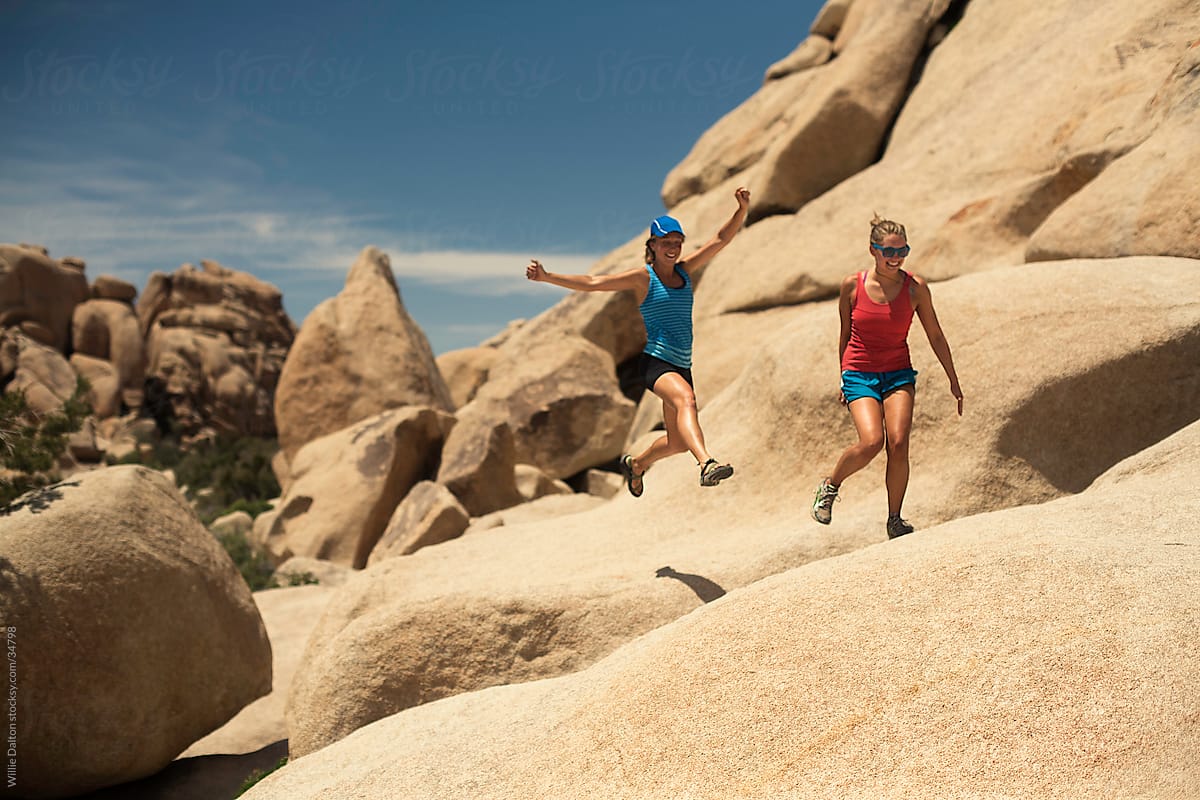 Two Women Jump Across Rock