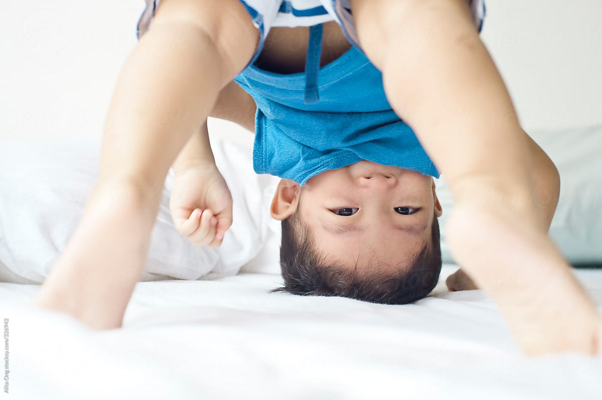 Upside down baby bending down and looking through his legs
