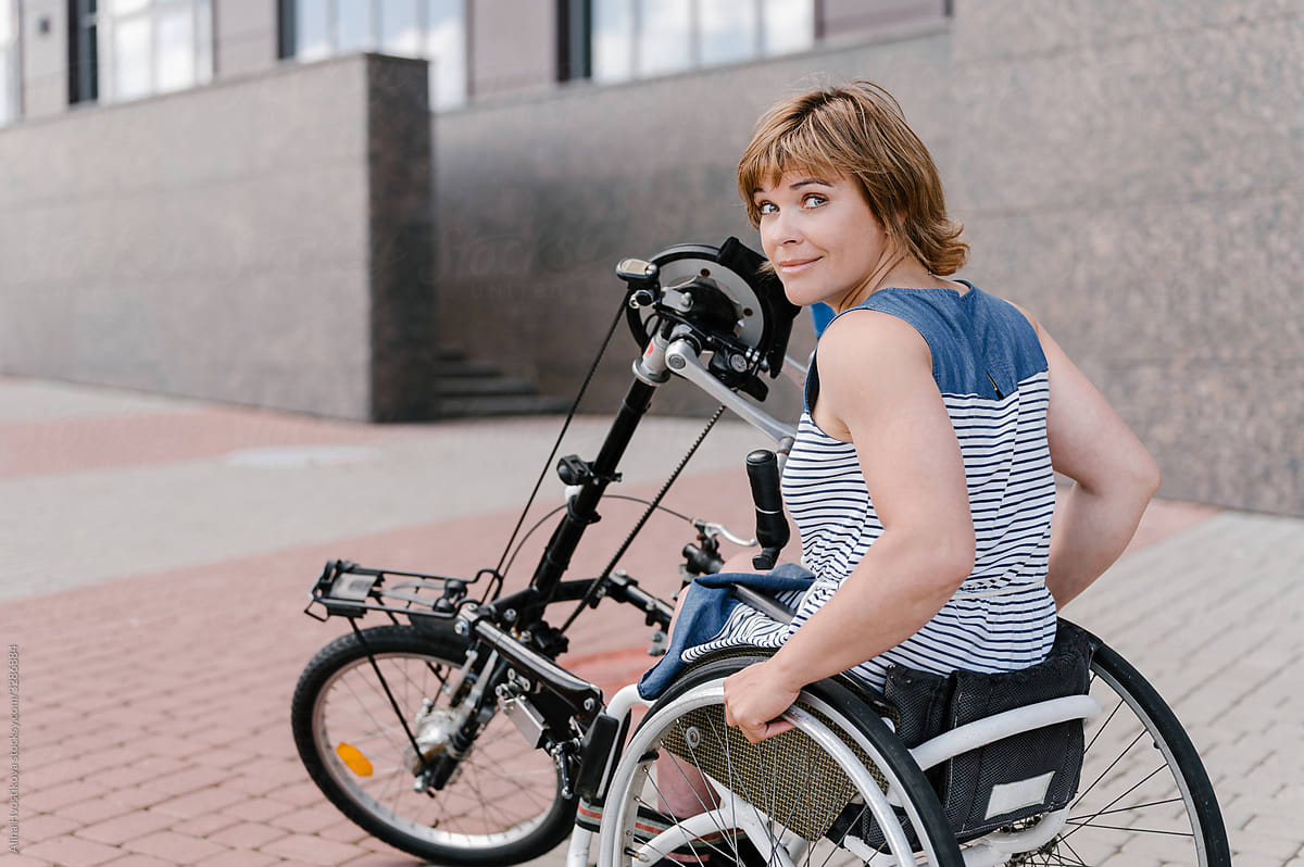 Positive woman on wheelchair with handbike