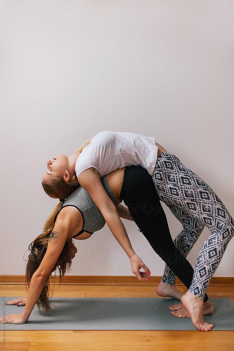 Two Women Doing Yoga Togethera by Stocksy Contributor Marija