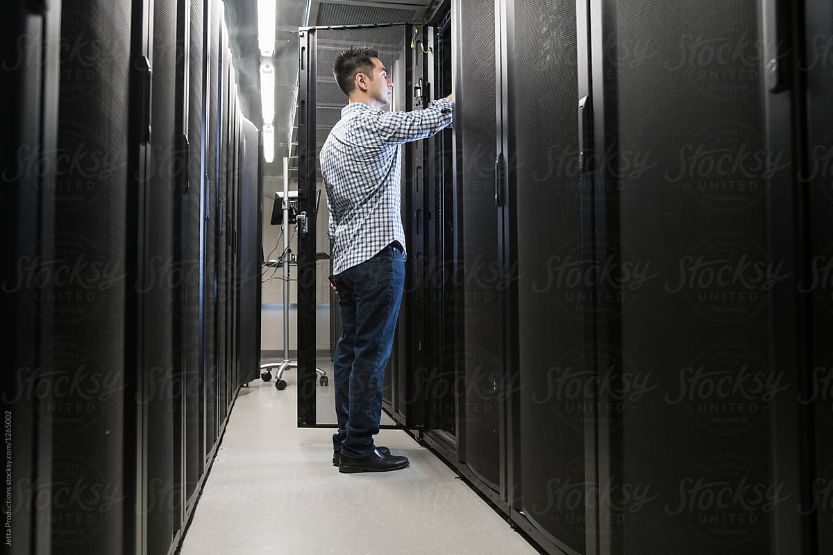 Technician works on server in cabinet in server room
