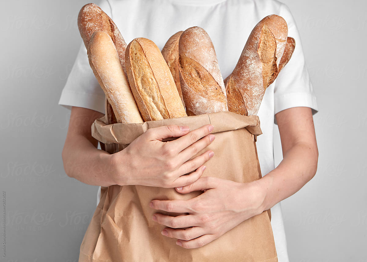 Bag of baguettes in woman's hands.