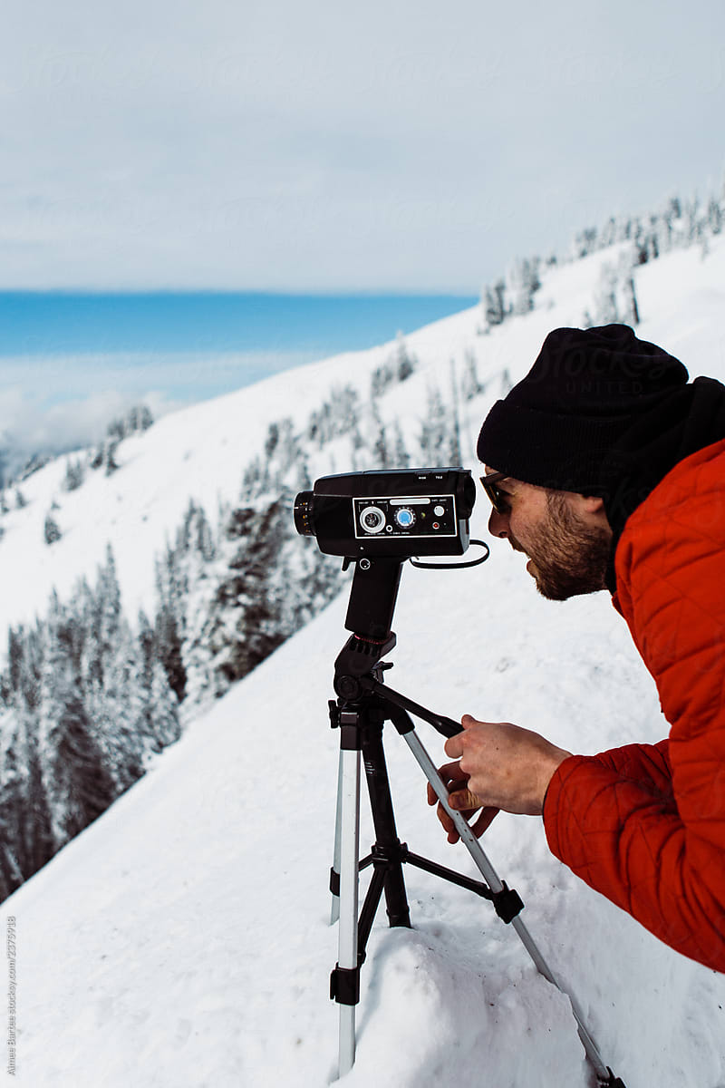 Man Filming with a Super 8 Camera on a Mountain