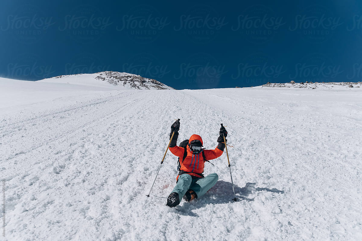 Tourist falling on snowy mountain slope in ski resort