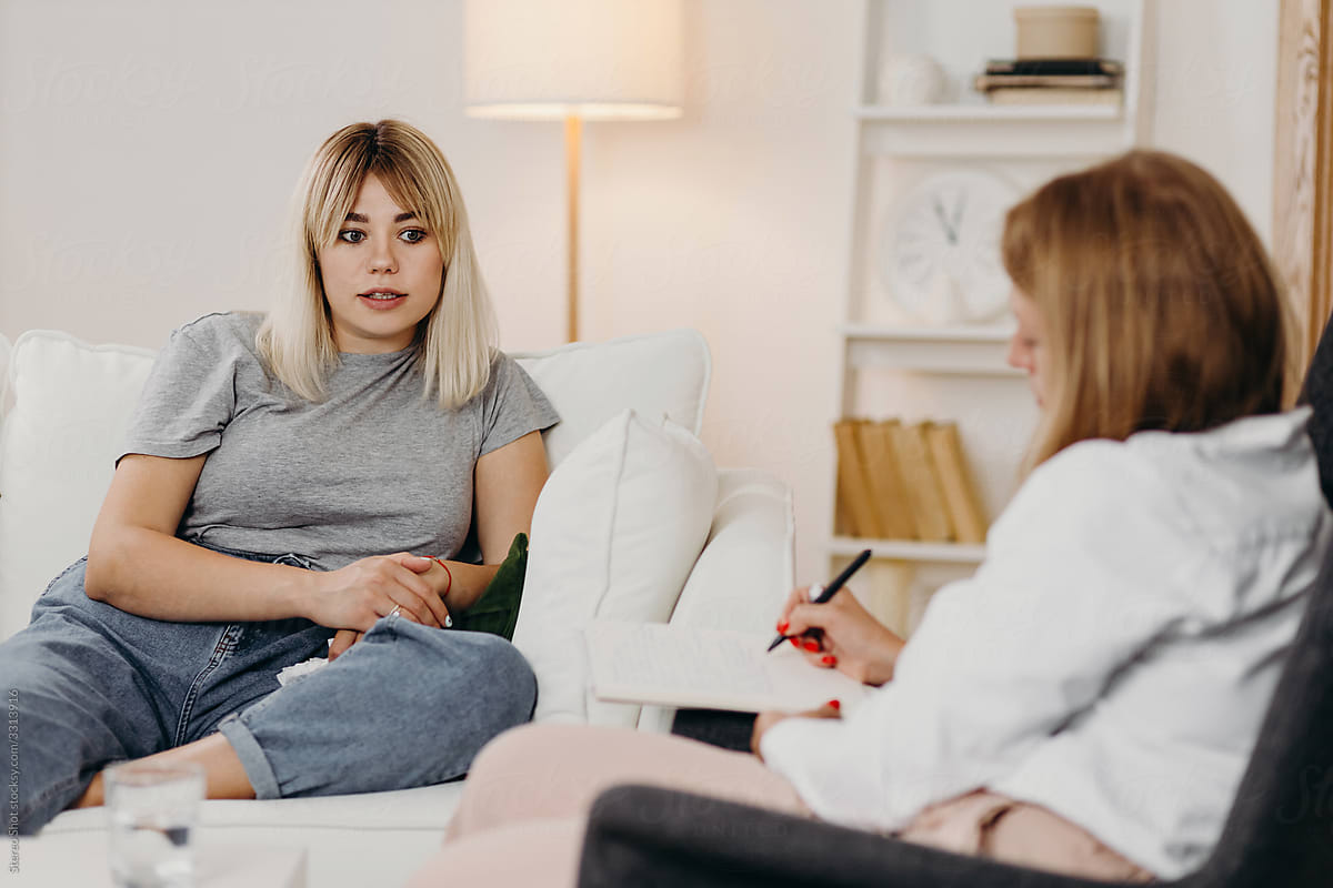 Young woman sharing feelings with psychotherapist