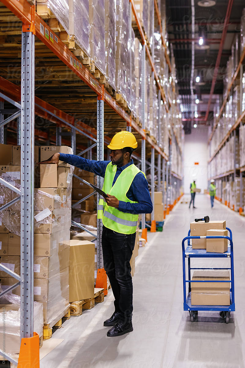 Foreign warehouse worker packing goods storage