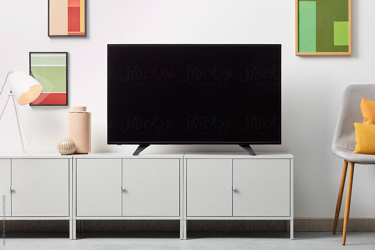 Black TV set on white cupboard indoors