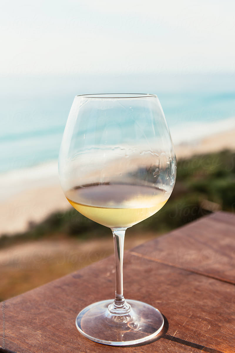 a glass of white wine by the ocean