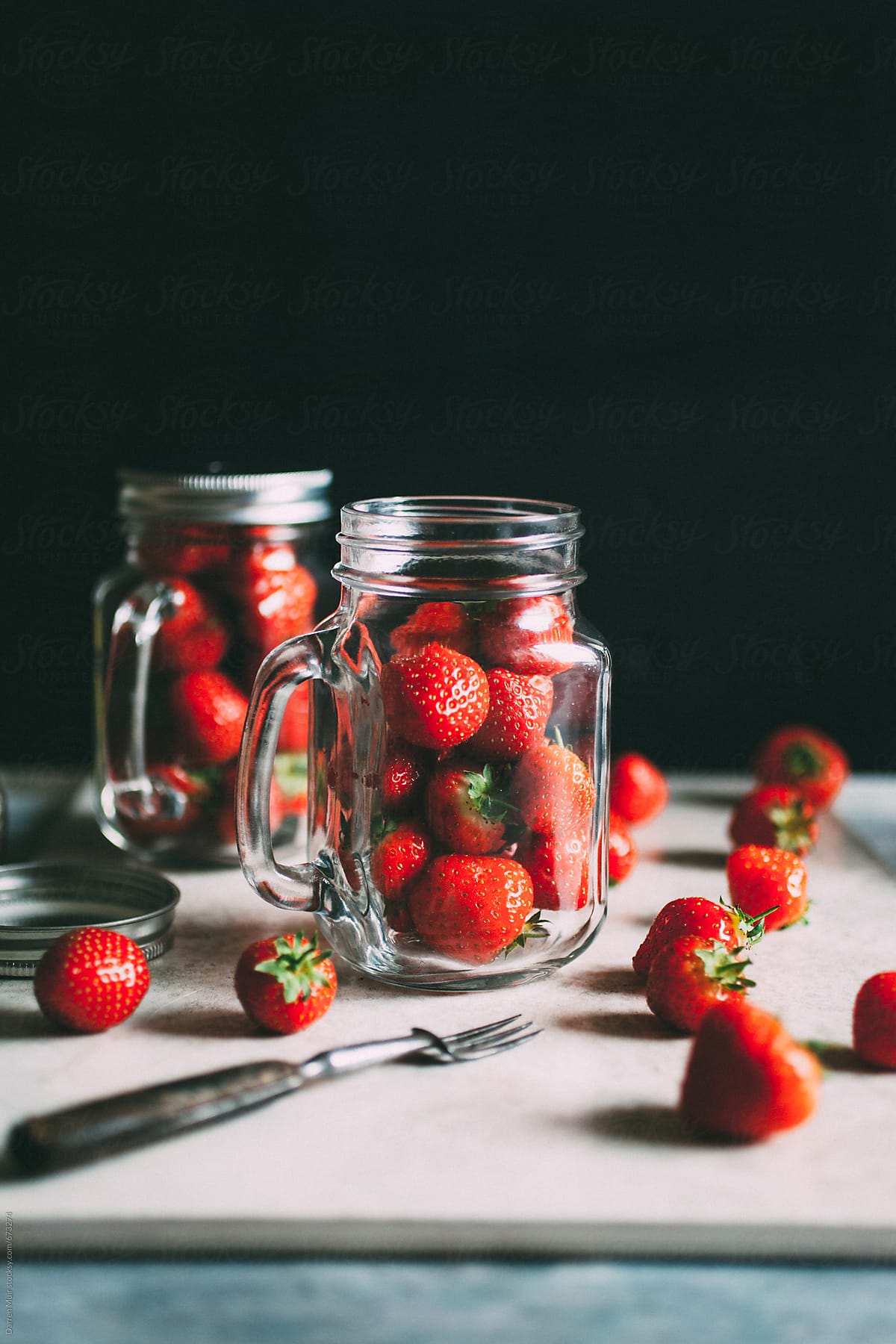 Strawberry\'s in glass jars.
