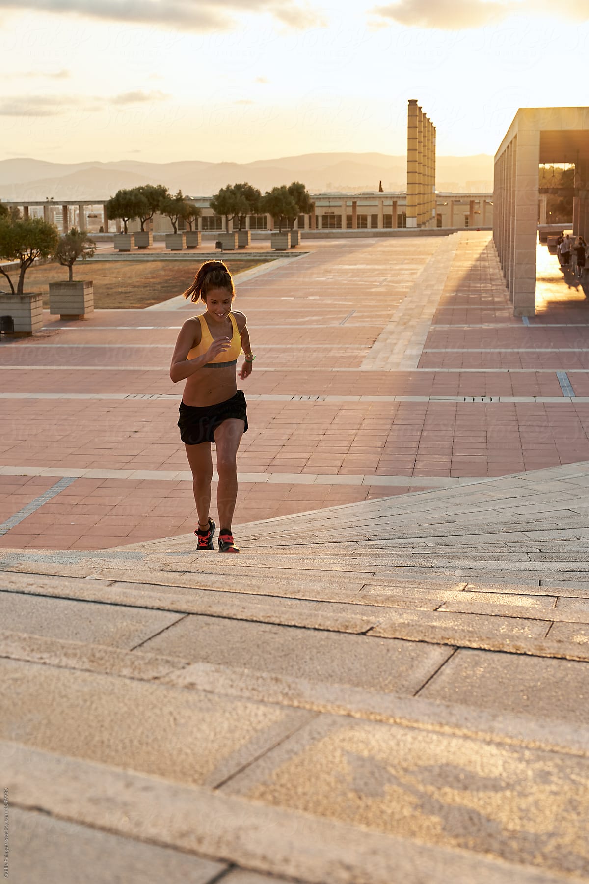 Happy Sportswoman Running On Stairs At Sundown By Stocksy Contributor Guille Faingold Stocksy