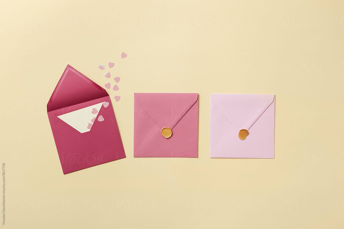 Pink envelope with paper hearts and closed envelopes