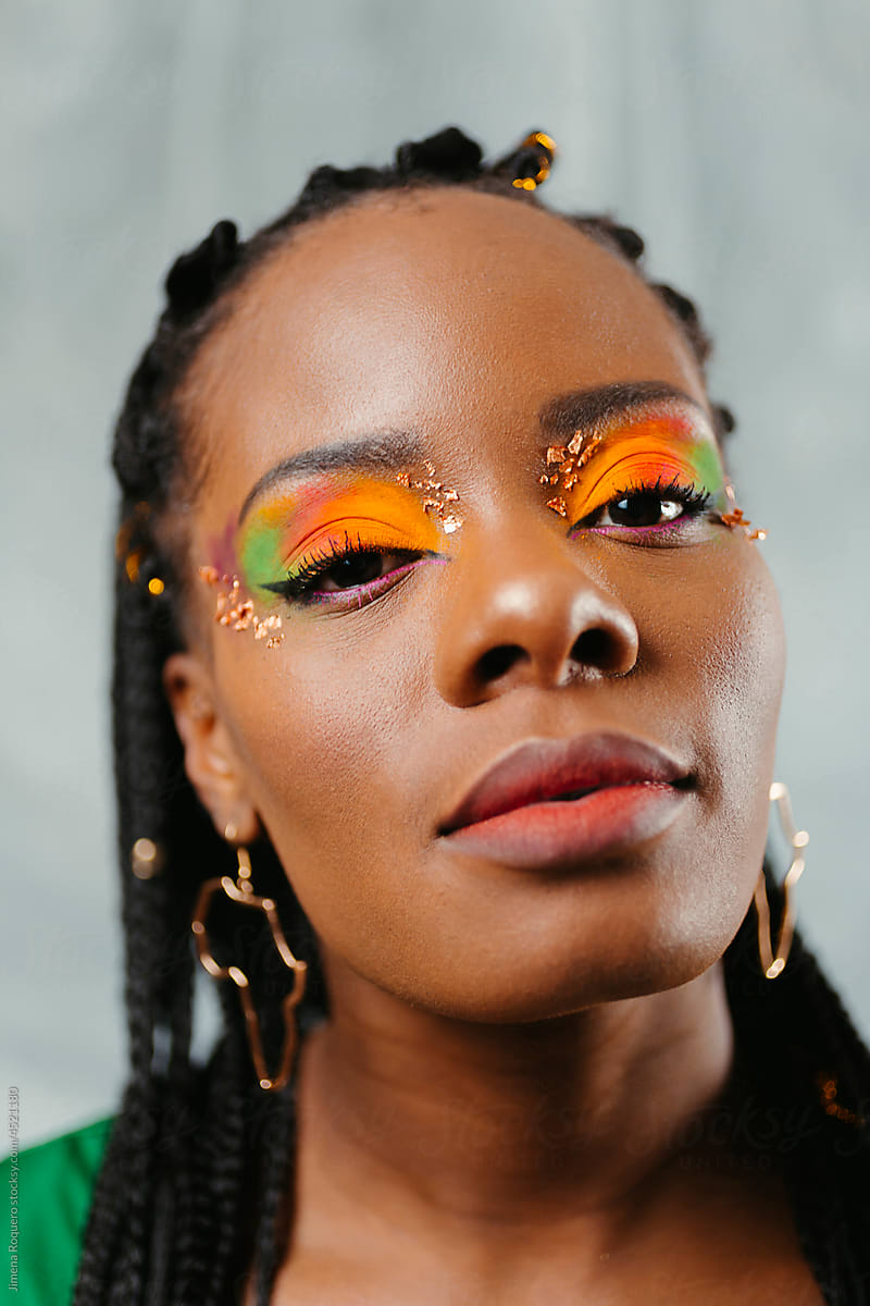 Woman with creative colorful eyeshadow and gold leafing makeup