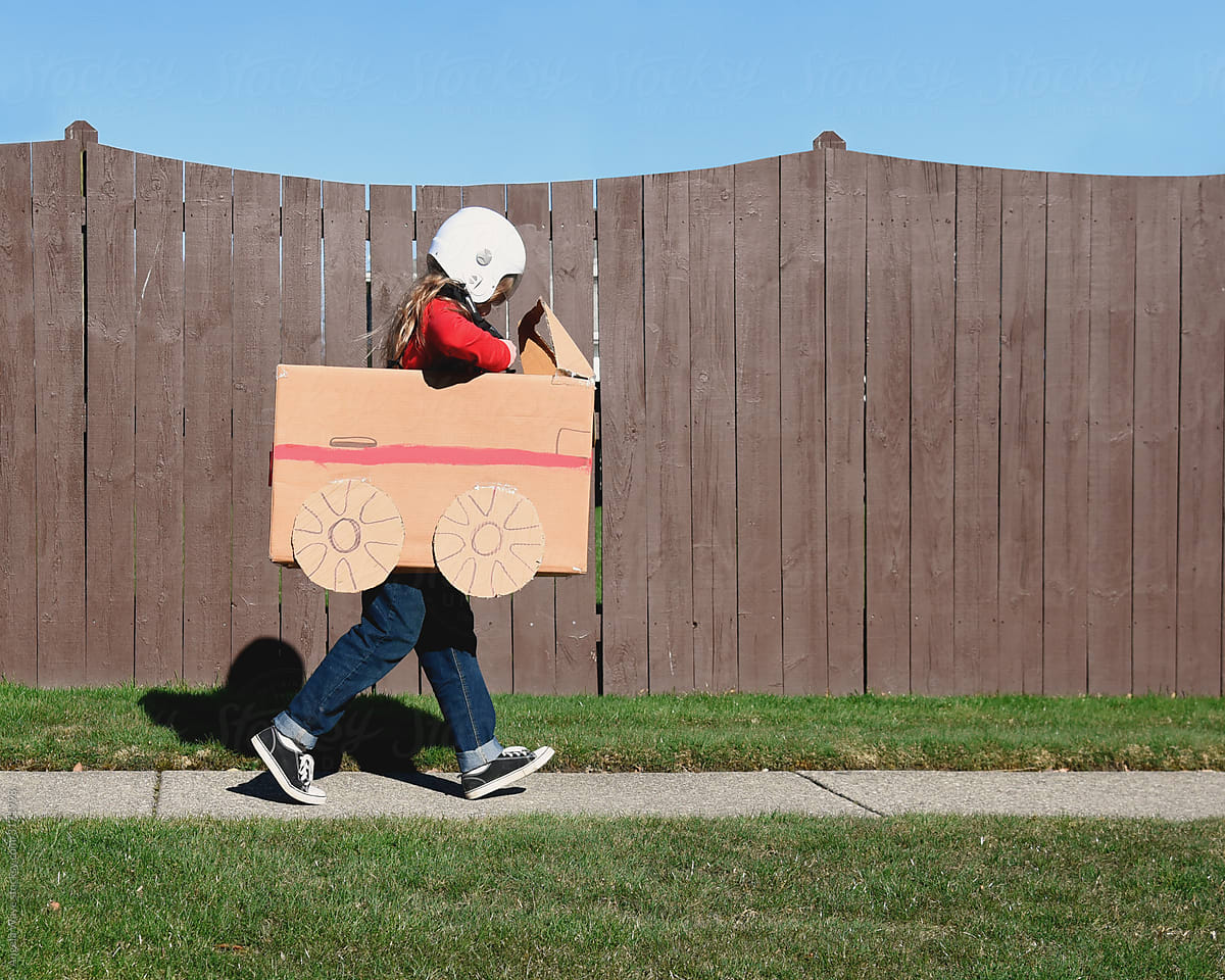 Child Running Down Sidewalk in Cardboard Car