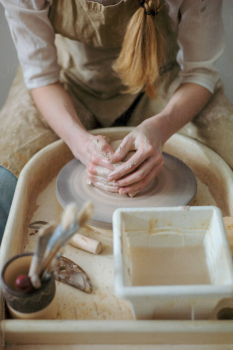 Woman sitting and working with clay