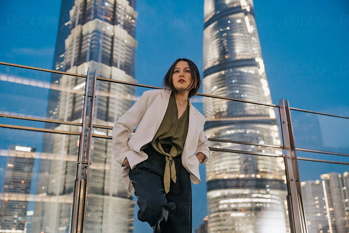 Asian woman standing before night city background
