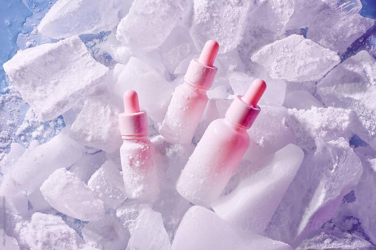 Summer skin care. Four pink bottles of cosmetic products in frozen.