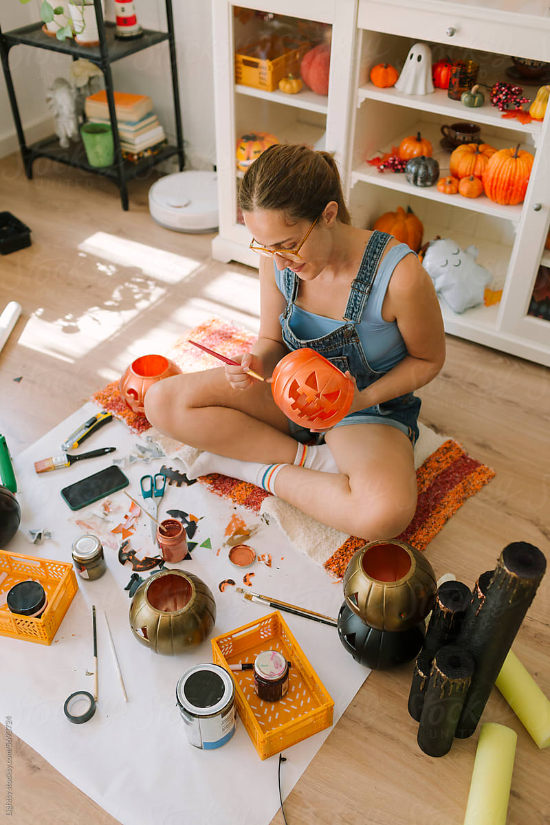 Woman painting Halloween decorations