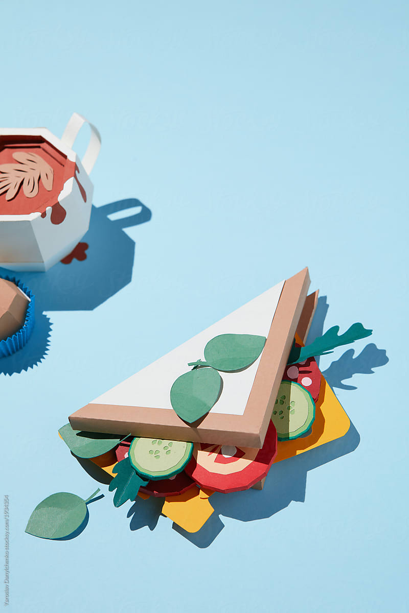 Paper craft sandwich with a cup of coffee on a blue background
