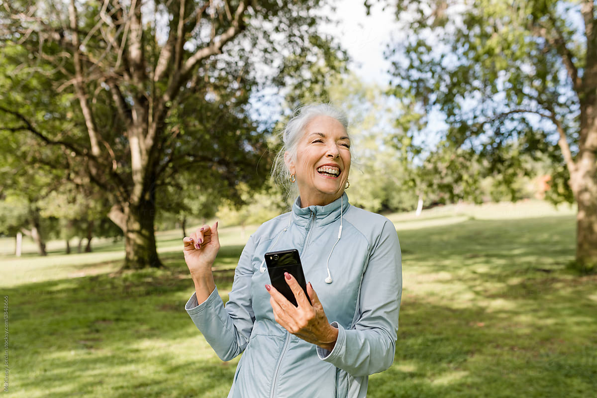 Senior Woman Laughs While Looking at her Phone