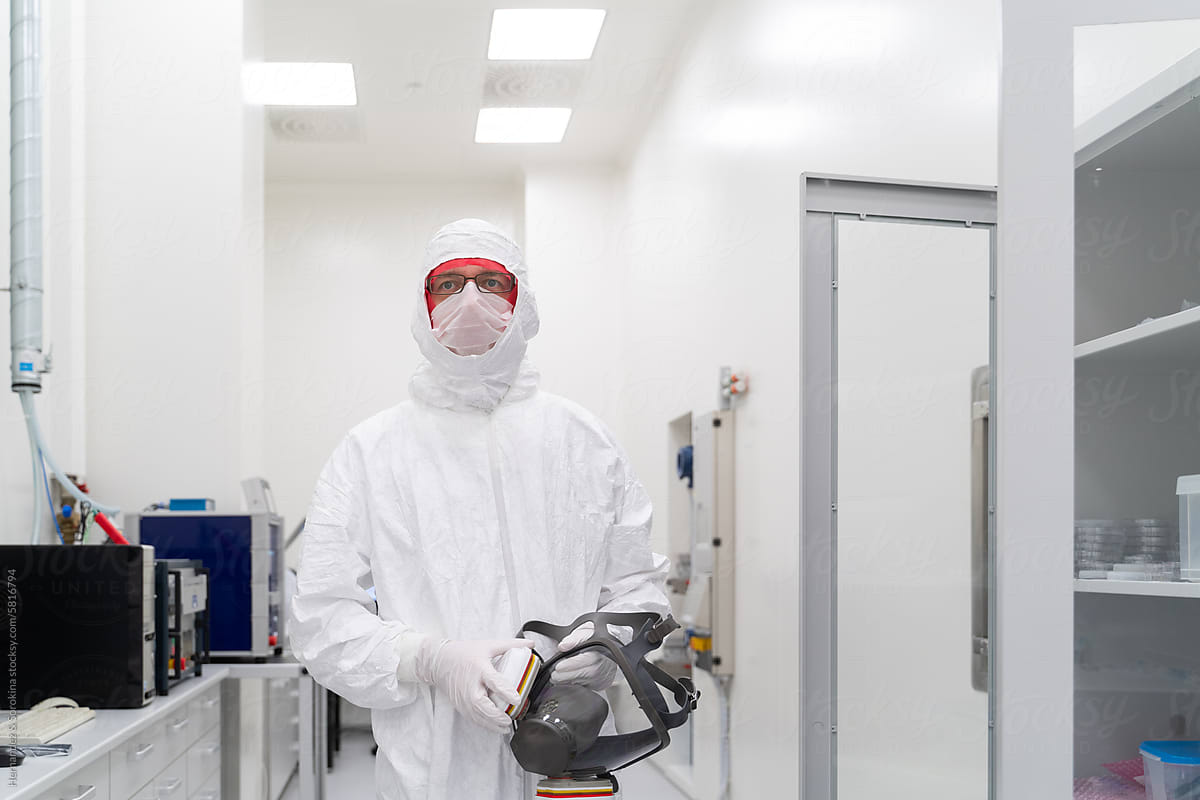 Researcher Standing At Clean Room Holding Helmet