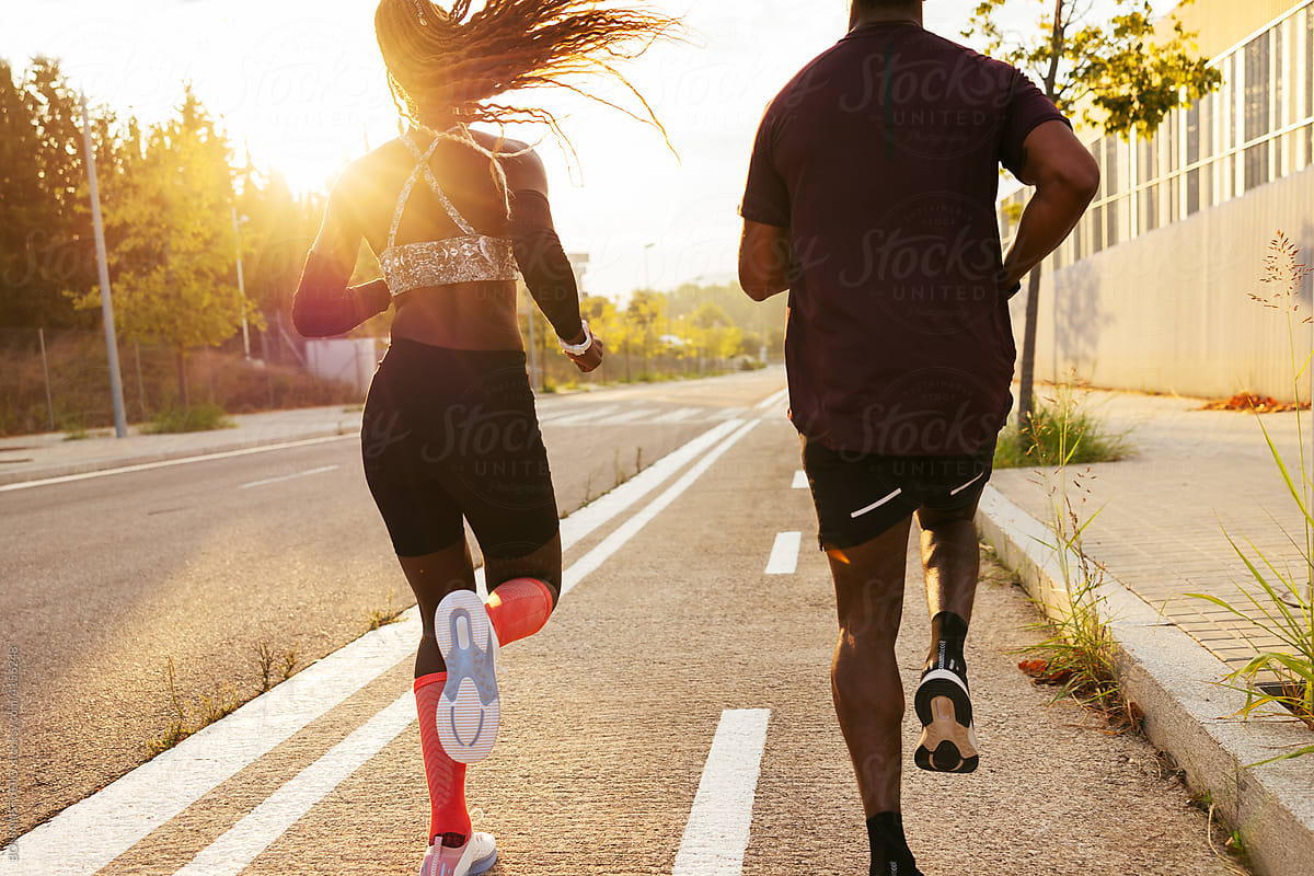 Woman with trainer running on road