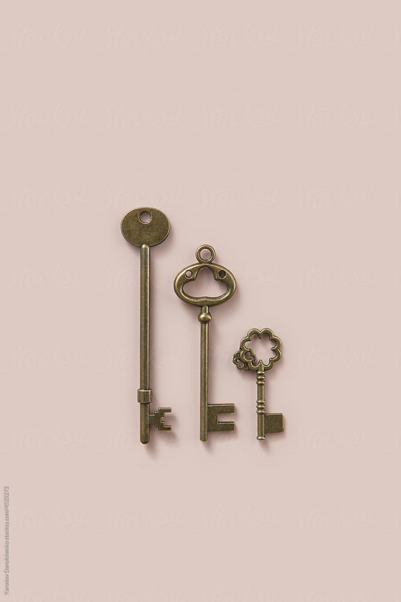 Three various antique keys lying on beige background
